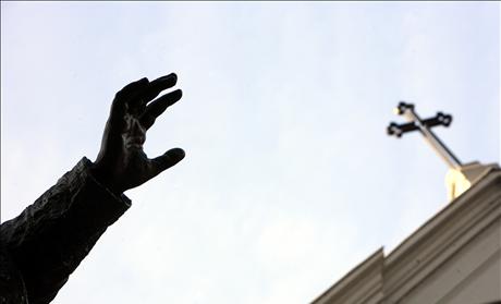 Hand of statue of Pope Benedict XV, seen under cross of St. Esprit Cathedral in Istanbul 
