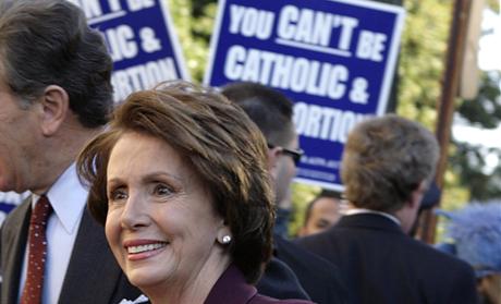 U.S. Speaker of the House elect Pelosi and her husband walk past abortion protesters as they arrive for an interfaith prayer service for House leadership in Washington