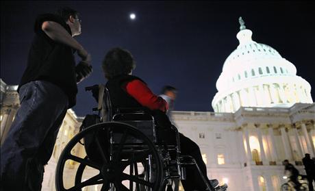  A woman in a wheelchair and her son are just a few of thousands of protestors remain late in the evening after a 'Kill the Bill' rally against Obama's health care legislation, on the grounds of the US Capitol in Washington