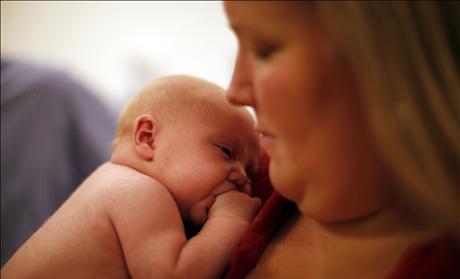 Michael Grabinski, two weeks old held by his mother Calee, waits to be measured by Dr. David Brumbaugh at The Children's Hospital in Aurora