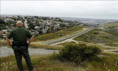 United States border patrol agent looks across the fence at Mexico as he patrols the U.S. border in San Ysidro, California,