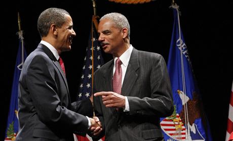 U.S. President Barack Obama speaks with Attorney General Eric Holder during a ceremonial installation at George Washington University in Washington