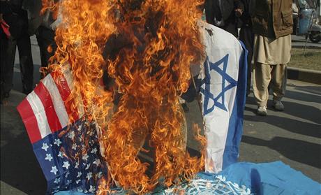 Lawyers burn an effigy of Israel's PM Olmert along with flags of the US, Israel and the United Nations in Multan, during a protest against the Israeli air strikes on Gaza