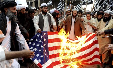 Supporters of religious party Jamiat-e-Ulema-e-Islam burn a U.S. flag to protest against the conviction of a Pakistani woman by a U.S. court, during a rally in Quetta