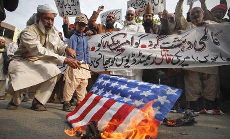 A man burns a mock U.S. flag during a rally to protest against U.S. special forces officer Raymond Davis in Lahore