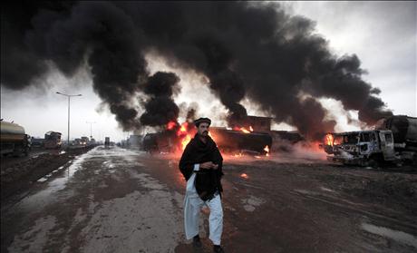 A fire fighter gestures in front of burning oil tankers which were attacked by unidentified gunmen on the outskirts of Peshawar