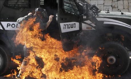 An Israeli border police officer is engulfed by flames after a petrol bomb was thrown at him during clashes with Palestinians in the mostly Arab neighborhood of Silwan in East Jerusalem