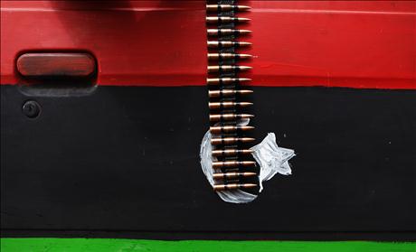 An ammunition belt hangs over a car door painted in the colours of the rebel Kingdom of Libya flag near Brega in eastern Libya