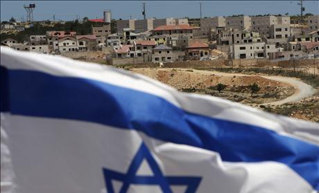 An Israeli flag waves on a hill near Elazar, in the Etzion settlement bloc