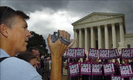 A tourist makes home movies of the crowd gathered at the US Supreme Court in Washington.