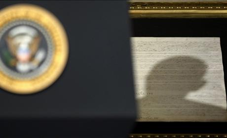 Shadow of head of U.S. President Obama falls upon copy of U.S. Constitution as he makes speech on national security in Washington