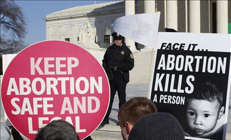 A police officer watches pro-life and pro-choice supporters demonstrating in Washington