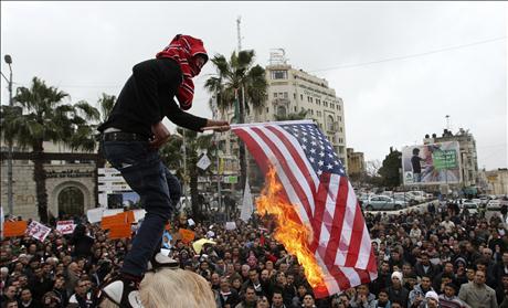 A Palestinian man burns the U.S. flag during a protest in support for Egyptian protesters in Ramallah