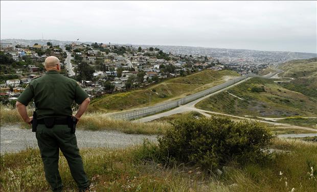 United States border patrol agent looks across the fence at Mexico as he patrols the U.S. border in San Ysidro, California,