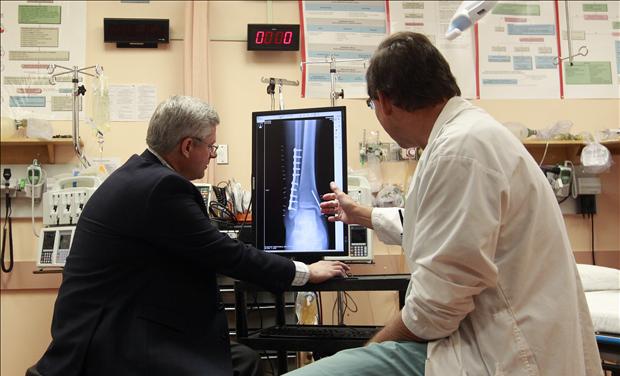Canada's PM Harper examines an X-ray with Doctor Corkal at Stanton Territorial Hospital in Yellowknife