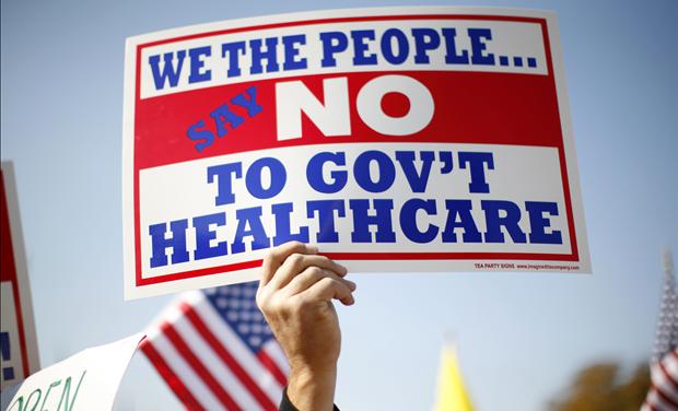 A demonstrator holds up a sign at a rally on healthcare on Capitol Hill in Washington - ObamaCare