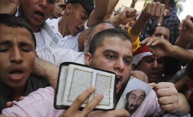 Islamists protest while holding a picture of Osama bin Laden and a copy of the Koran during a protest in Cairo
