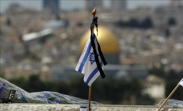 An Israeli flag is placed on the grave of a fallen soldier at the military cemetery on the Mount of Olives in Jerusalem