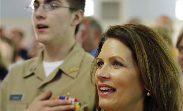 U.S. Congresswoman and likely Republican presidential candidate Michele Bachmann sings 'God Bless America' next to a current member of the U.S. Navy at an event to pay tribute to veterans on Memorial Day in Dover