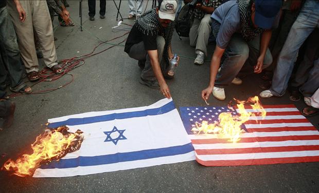 Supporters of Shi'ite Muslims burn U.S. and Israeli flags during a protest against the 61th anniversary of the foundation of the State of Israel in Karachi