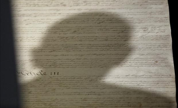 Shadow of head of U.S. President Obama falls upon copy of U.S. Constitution at National Archives in Washington