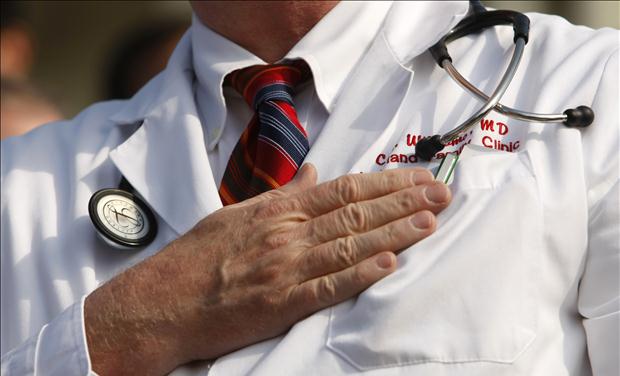 A doctor puts his hand over his chest during a "House call" rally against proposed healthcare reform legislation at the Capitol in Washington