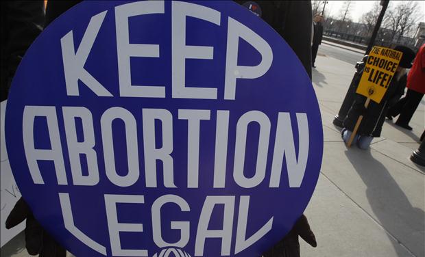 A pro-choice supporter carries a placard near a pro-life supporter during a demonstration in Washington