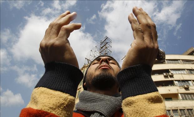 An Egyptian anti-government protester prays at Tahrir Square in downtown Cairo