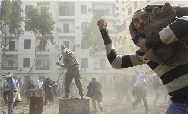 Opposition supporters throw stones at pro-Mubarak demonstrators in Tahrir Square in Cairo