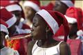 A girl plays with a noise maker while children wait for a presidential speech during a children's Christmas gathering at the national palace in Port-au-Prince