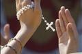A woman, holding her rosary, claps her hands in time with music during a youth rally for Pope Benedict XVI in Yonkers New York