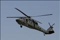 A U.S flag flutters as a Blackhawk helicopter flies over U.S. military camp in Mosul