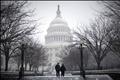 A couple walks on the grounds of the U.S. Capitol Building during a snow storm in Washington
