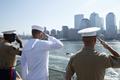 U.S. Marine Corps and Navy personnel salute on the deck of the USS Iwo Jima as the amphibious assault ship passes Ground Zero while moving up the Hudson River for Fleet Week