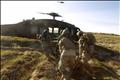 A Blackhawk helicopter from CCO., 1-214 AVN flies overhead as U.S. Marines and members of the Afghan Army carry a wounded Afghan soldier to a helicopter during a Medevac mission in southern Afghanistan's Helmand province