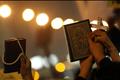 Egyptian Muslims and Christians hold a Koran and a cross in the Shobra district of Cairo