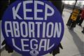 A pro-choice supporter carries a placard near a pro-life supporter during a demonstration in Washington