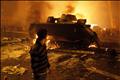 A protester looks at a burnt Egyptian Army armoured vehicle in downtown Cairo