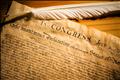 Declaration of Independence with feather quill on wood surface