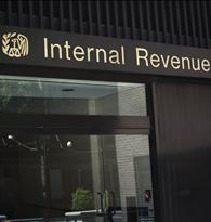 Woman walks out of Internal Revenue Service building (IRS)